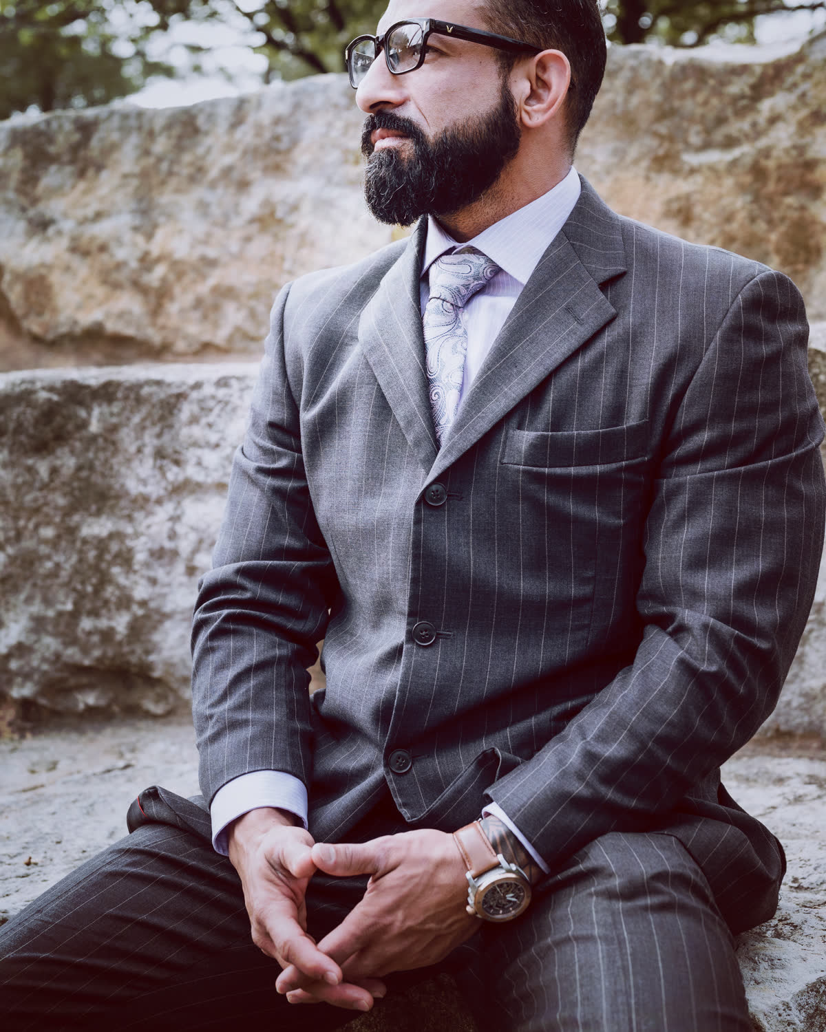 The Guy Valentino, seated in a charcoal pinstripe suit